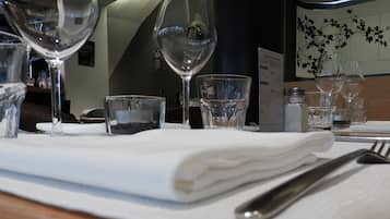 Mesa posta com taças de vinho, um copo de água e um guardanapo dobrado.