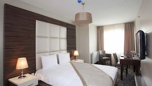 A hotel room with a large bed, two bedside tables, a desk, a chair, a television, and a window with curtains. - Derpa Suite Hotel Osmanbey (Istanbul)