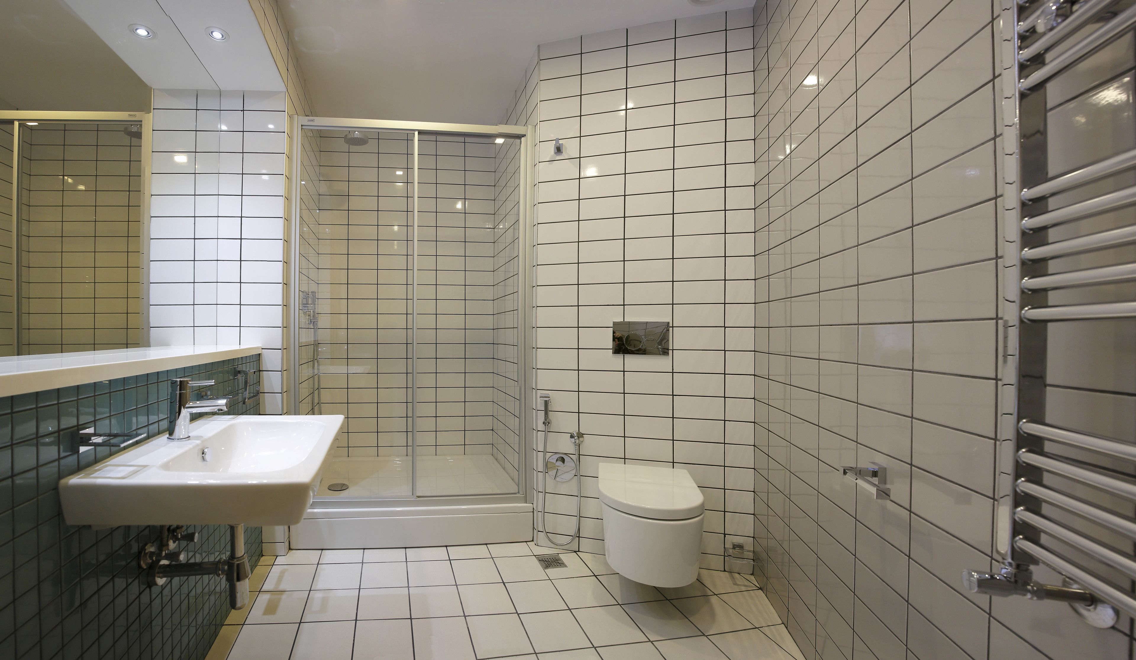 Ein modernes Badezimmer mit einer Duschkabine, einem weißen Waschbecken und einer Toilette.