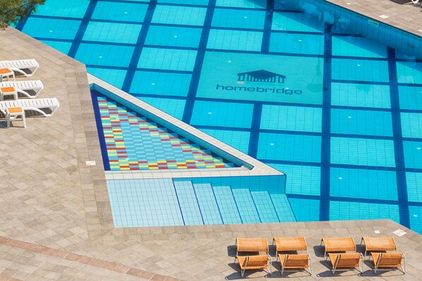 A swimming pool with a checkered pattern, lounge chairs, and a logo for 'homebridge'.