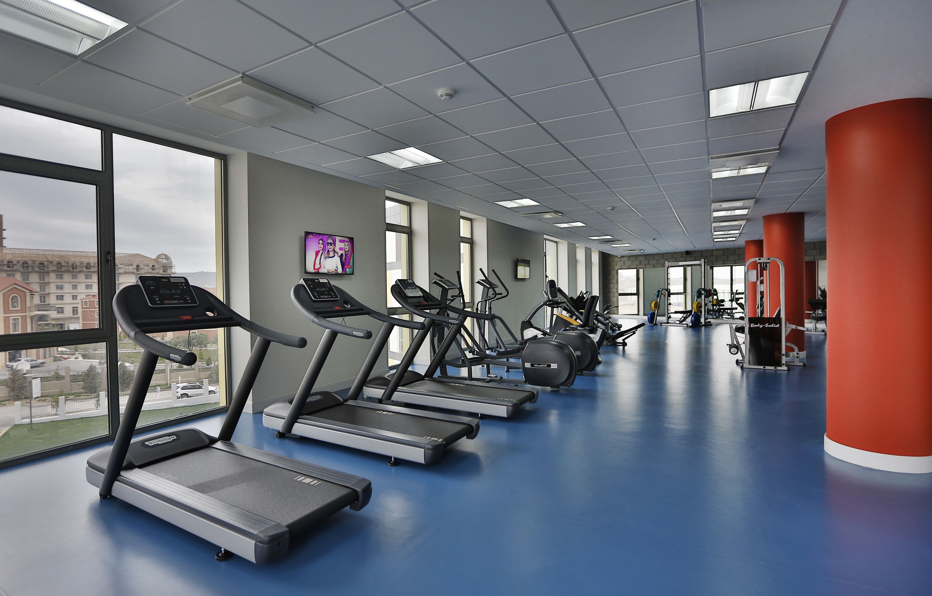 A gym with treadmills, stationary bikes, and weight machines.