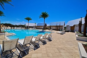 A pool area with lounge chairs and palm trees. - Coastal Cottage 3 Bedroom Condo By Coastal Dreamin (Santa Rosa Beach)