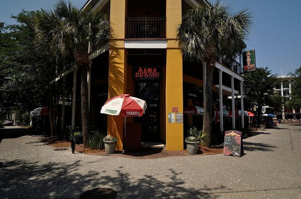 Un edificio con un letrero que dice "Acme Oyster House" y un paraguas rojo y blanco.