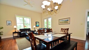 A spacious living room with a dining area, hardwood floors, and a chandelier. - Redfish Village M2 214 3 Bedroom Condo By Coastal Dreamin (Santa Rosa Beach)