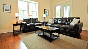 A living room with two leather sofas, a coffee table, and two lamps. - Redfish Village M2 214 3 Bedroom Condo By Coastal Dreamin (Santa Rosa Beach)