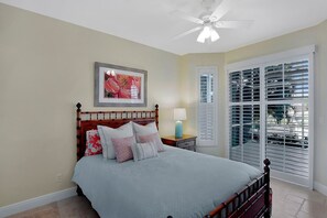 A bedroom with a bed, a ceiling fan, a window with blinds, and a framed picture on the wall. - COPPER20 5 Bedroom Holiday Home by Marco Naples Vacation Homes (Marco Island)