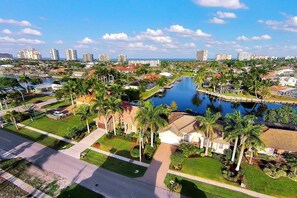 A residential area with a large body of water, palm trees, and a marina. - COPPER20 5 Bedroom Holiday Home by Marco Naples Vacation Homes (Marco Island)