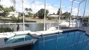 A swimming pool with a view of a marina and palm trees. - KEN486 3 Bedroom Holiday Home by Marco Naples Vacation Homes (Marco Island)