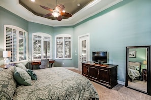 A bedroom with a bed, dresser, TV, and large windows. - MAJ8978 4 Bedroom Holiday Home by Marco Naples Vacation Homes (Naples)