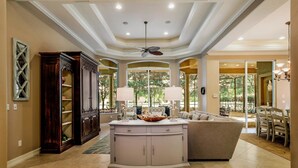 A spacious living area with a large white cabinet, a beige sofa, and a dining table with chairs. - MAJ8978 4 Bedroom Holiday Home by Marco Naples Vacation Homes (Naples)