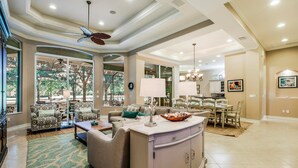 A spacious living room with a large dining area, a kitchen, and a view of the outdoors. - MAJ8978 4 Bedroom Holiday Home by Marco Naples Vacation Homes (Naples)