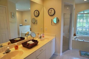 Ein Badezimmer mit zwei Waschbecken, einem großen Spiegel und einer Dusche.
