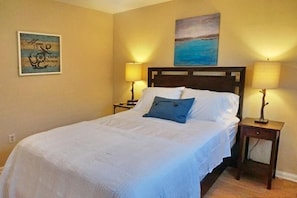 A neatly made bed with white and blue bedding, two bedside lamps, and a painting on the wall. - NP97TH 730 3 Bedroom Holiday Home by Marco Naples Vacation Homes (Naples)