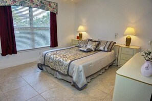 A bedroom with a bed, two bedside tables with lamps, a nightstand, and a dresser. - SHEN1124 3 Bedroom Holiday Home by Marco Naples Vacation Homes (Marco Island)