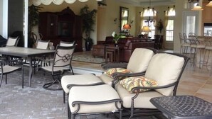 A spacious living area with a dining table, chairs, and a sofa.
