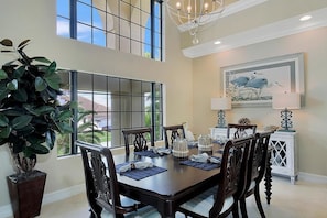 A dining area with a large table, chairs, and a potted plant. - SPIN516 5 Bedroom Holiday Home by Marco Naples Vacation Homes (Marco Island)
