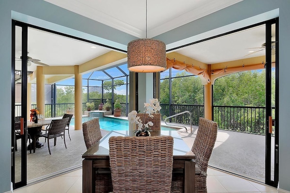 Relax in this serene space with a dining table for four, a pendant light, and a beautiful outdoor view.