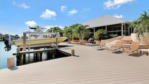 A marina with a dock, a boat, and a building with a covered area. - WH1074 3 Bedroom Holiday Home by Marco Naples Vacation Homes (Marco Island)