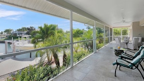 A spacious balcony with large windows overlooking a marina and greenery. - WH1074 3 Bedroom Holiday Home by Marco Naples Vacation Homes (Marco Island)