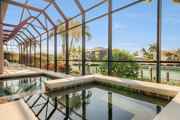 A pool area with clear views of a river and surrounding buildings.