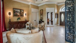 Un salon spacieux avec un canapé beige, un meuble en bois et un tableau accroché au mur.