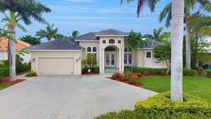A two-story house with a garage, a front porch, and a landscaped driveway.
