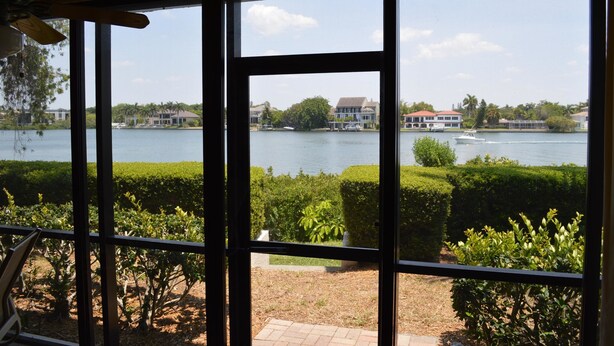 A view from inside a building looking out over a lake with houses and boats.