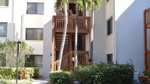 A residential building with a pathway, palm trees, and a sign indicating building numbers. - Cove II 127F 2 Bedroom Condo By Midnight Cove II (Siesta Key)