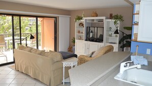 A living room with a sofa, a television, and a cabinet with decorative items.