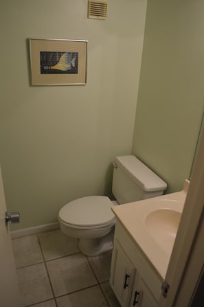 A small bathroom with a toilet, a sink, and a framed picture on the wall. - Cove II 323F 2 Bedroom Condo By Midnight Cove II (Siesta Key)