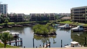 A marina with boats docked, surrounded by modern buildings and greenery. - Cove II 624D 3 Bedroom Holiday home By Midnight Cove II (Siesta Key)