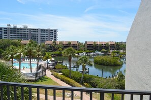 A hotel with a pool, palm trees, and a water body. - Cove II 633F 2 Bedroom Condo By Midnight Cove II (Siesta Key)