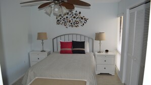 A bedroom with a bed, two bedside tables, a ceiling fan, and a window with blinds. - Cove II 732F 2 Bedroom Condo By Midnight Cove II (Siesta Key)