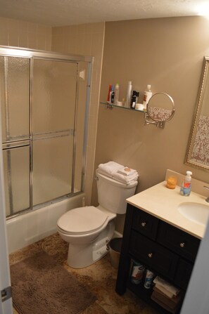 A bathroom with a glass shower enclosure, a toilet, a sink, and a vanity with toiletries. - Cove II 811F 2 Bedroom Condo By Midnight Cove II (Siesta Key)