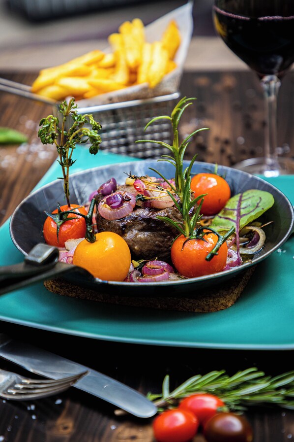 A plate of food with a fork and knife on a teal tablecloth. - Hotel Alte Post Flensburg (Flensburg)