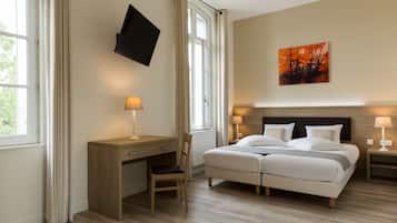 A bedroom with a bed, bedside tables, a desk, a chair, a television, and a painting on the wall.