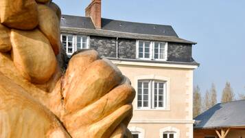 Un bâtiment sur lequel se trouve une imposante statue en pierre, placée en évidence à l’avant.
