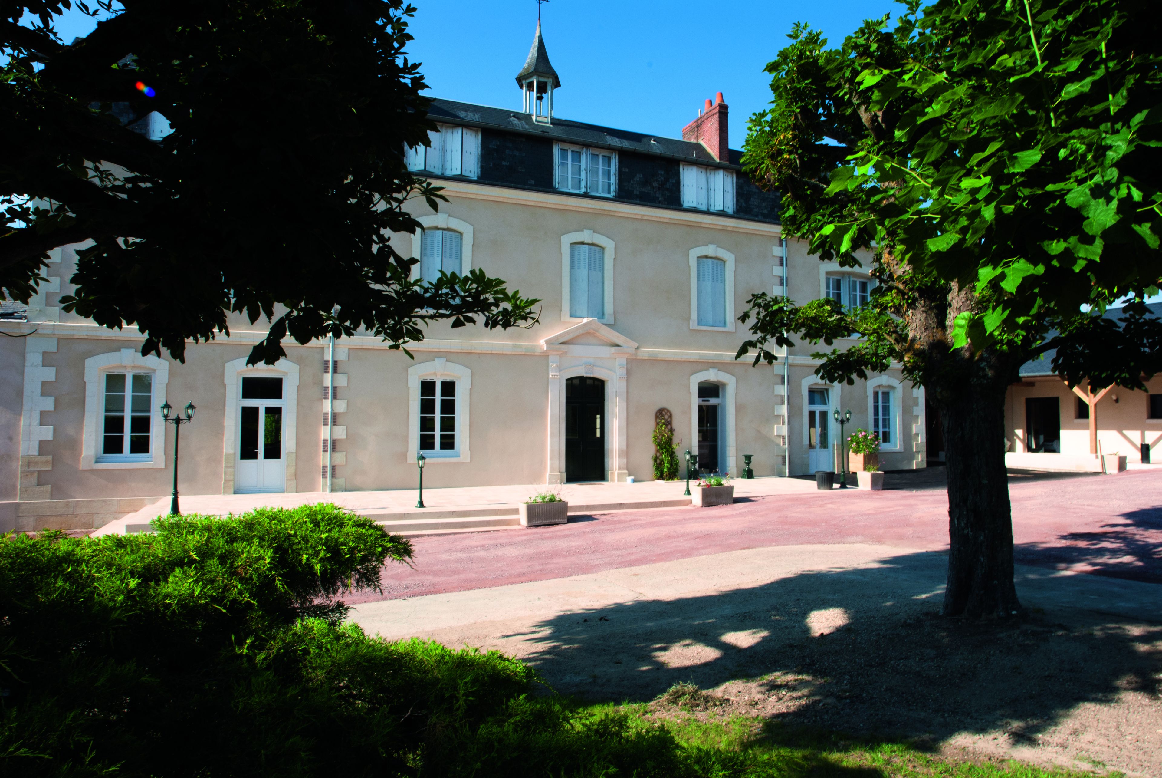 A historic building with a symmetrical facade, large windows, and a central entrance.