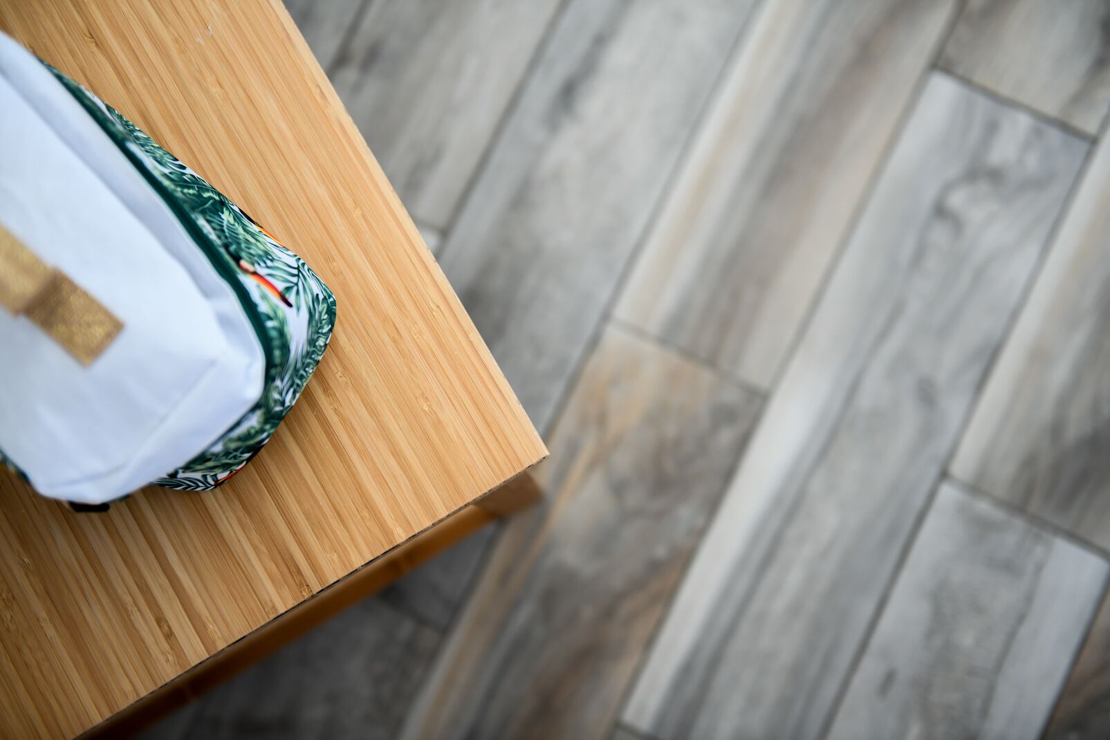A wooden table with a white shirt and a patterned garment on it.