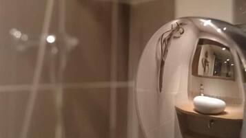 Une salle de bain avec un miroir qui reflète un lavabo et des toilettes.