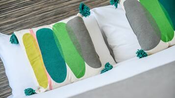 Un canapé blanc agrémenté de coussins colorés aux motifs abstraits et aux franges.