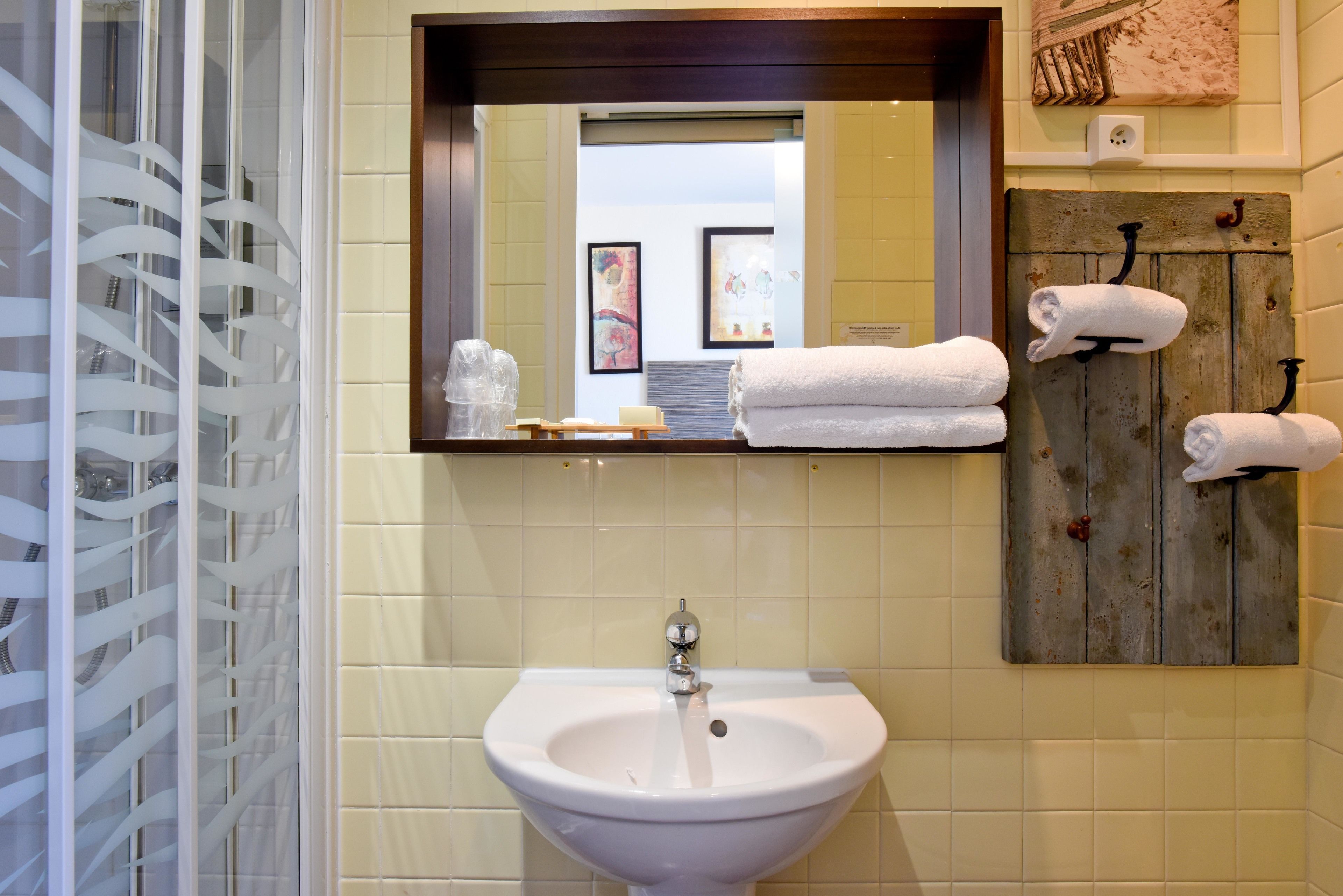 A bathroom with a sink, mirror, and towel rack.
