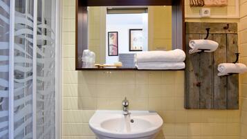 A bathroom with a sink, mirror, and towel rack.