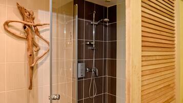 Ein modernes Badezimmer mit Duschkabine aus Glas, Wanddeko aus Holz und Fliesenboden.