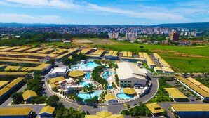 A large hotel complex with multiple swimming pools, a central courtyard, and a view of the surrounding cityscape. - L'acqua diRoma - Caldas Vip (Caldas Novas)
