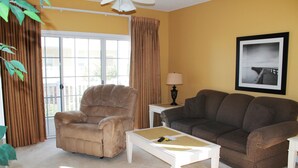 A living room with a beige armchair, a brown sofa, and a white coffee table.