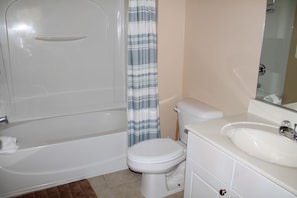 A bathroom with a bathtub, toilet, and sink.