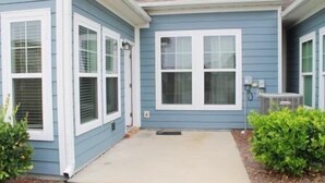 A two-story house with a front porch, a small entryway, and a garage. - 3804 Bay Village (North Myrtle Beach)