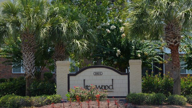 A sign with the name "Irwood" and the number "5801" in front of a building surrounded by palm trees and shrubs. - 434 Ironwood (North Myrtle Beach)