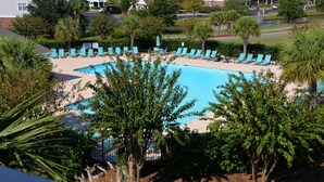 A pool area with lounge chairs and a view of hotel buildings in the background. - 434 Ironwood (North Myrtle Beach)